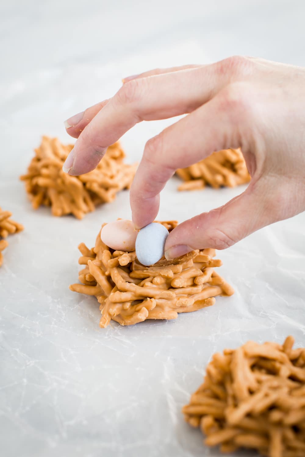 Immagine di come mettere le uova di caramella nei biscotti nido di uccelli.