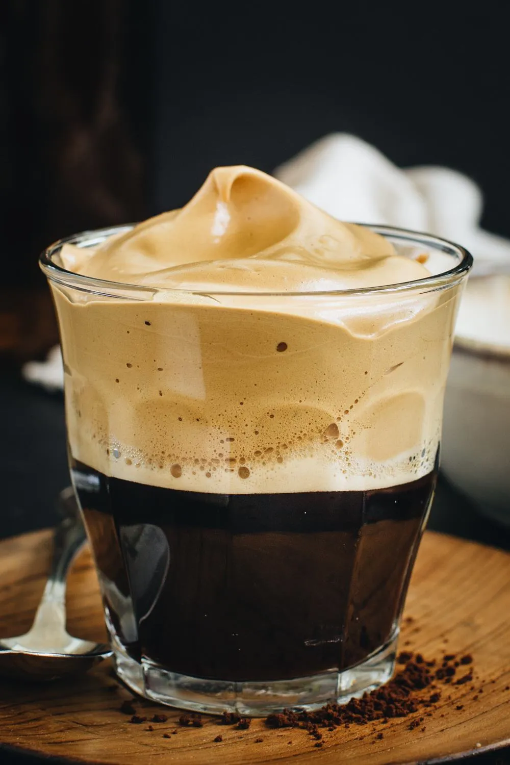 close up of beaten coffee over espresso in clear glass