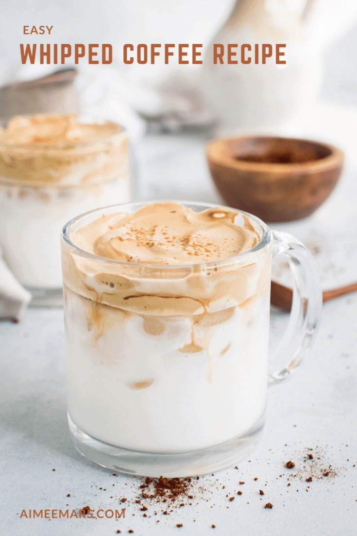 Whipped coffee in a clear glass mug.