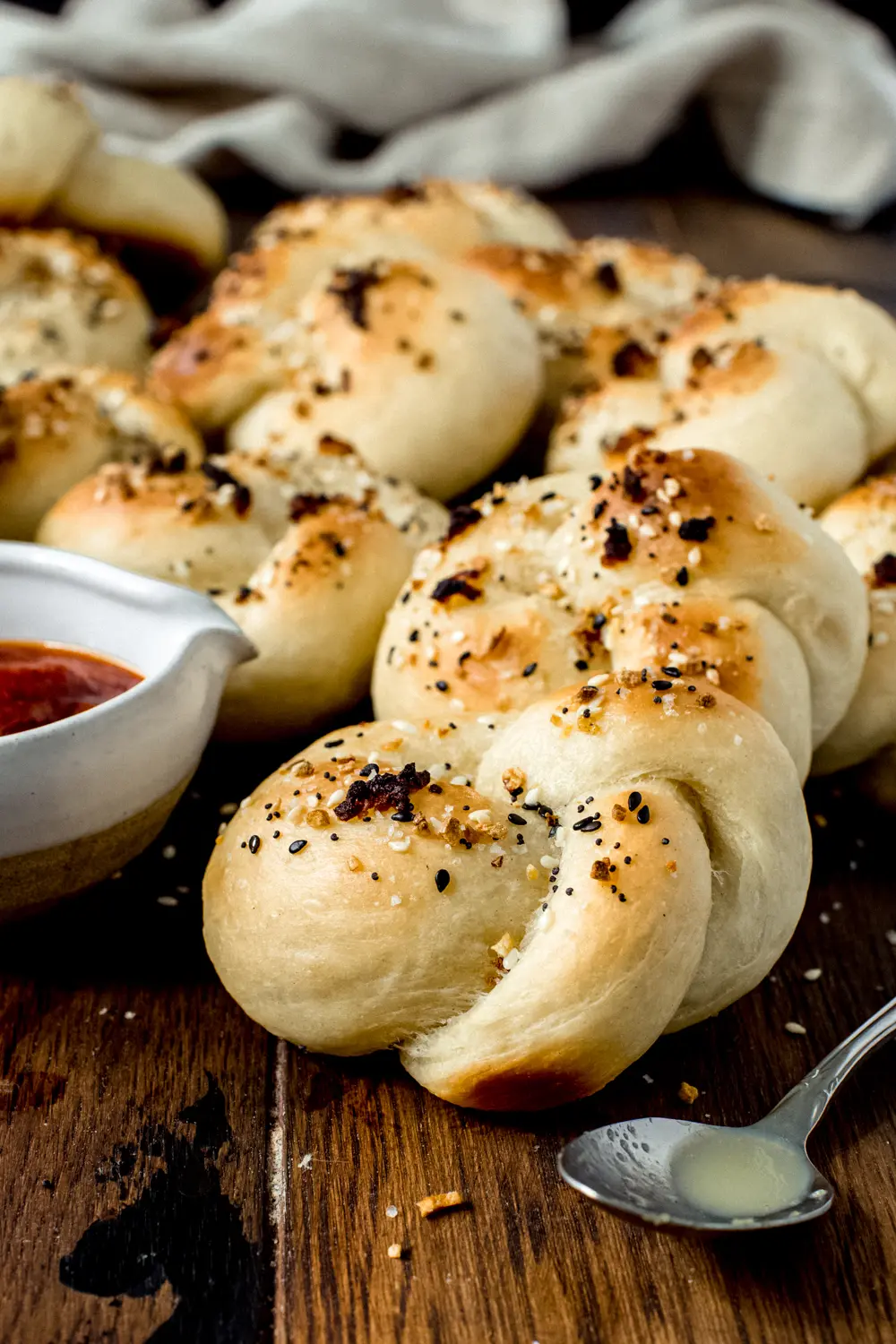 everything soft garlic knots recipe with dipping sauce and silver spoon