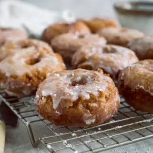 Sour cream donuts on a wire rack.