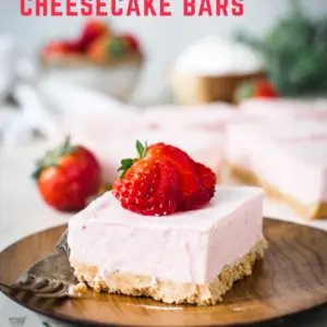 strawberry cheesecake bar on wooden plate with red lettering at top of page