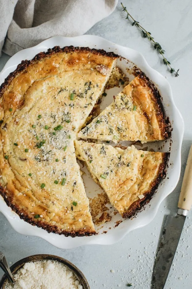 top view of quiche with 2 slices cut out in a white pie dish