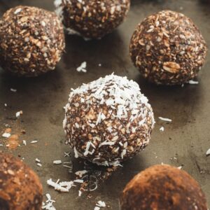 Close up of coconut covered bliss ball surrounded by others.