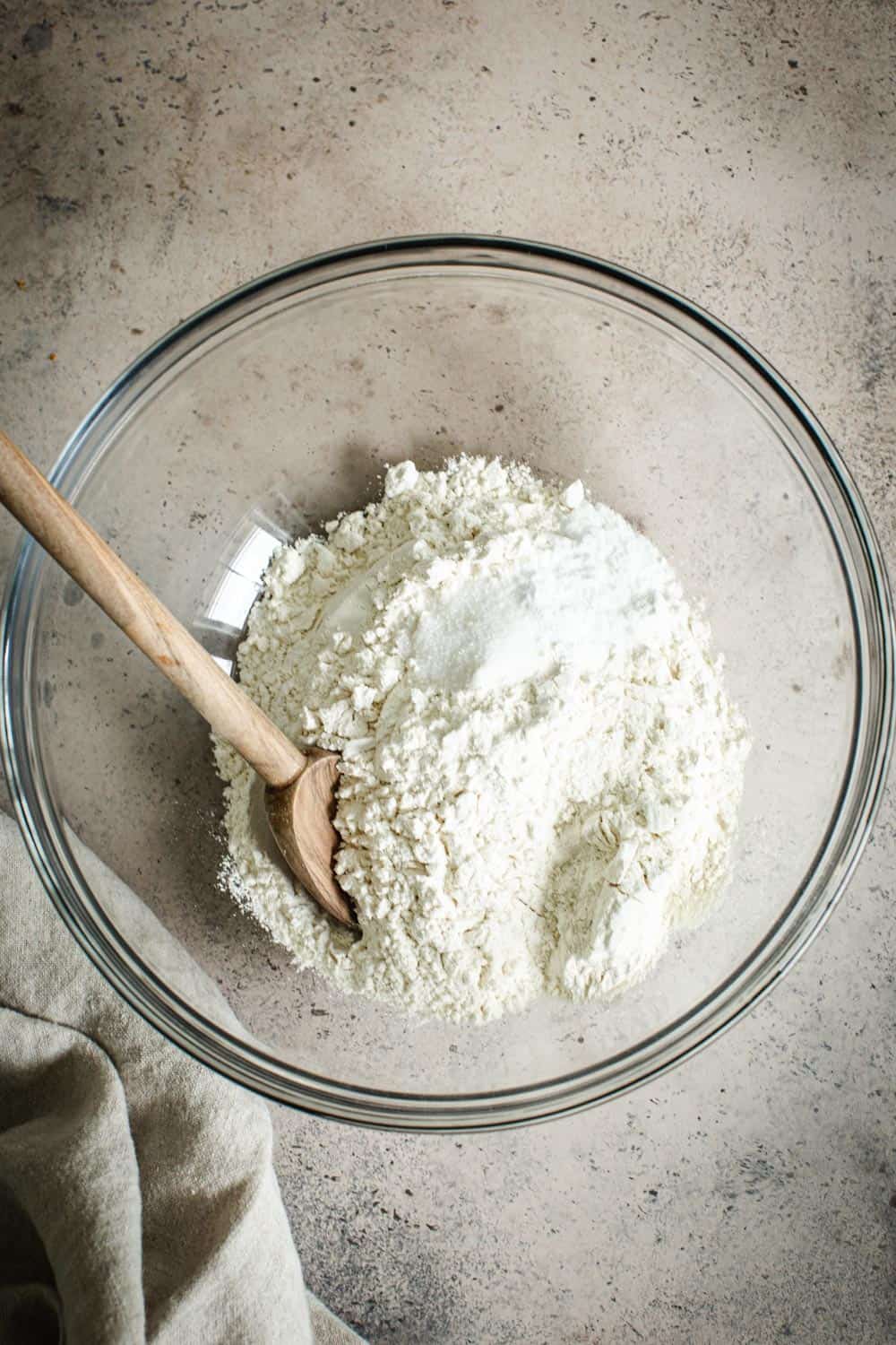Dry ingredients for banana muffins in a glass mixing bowl.