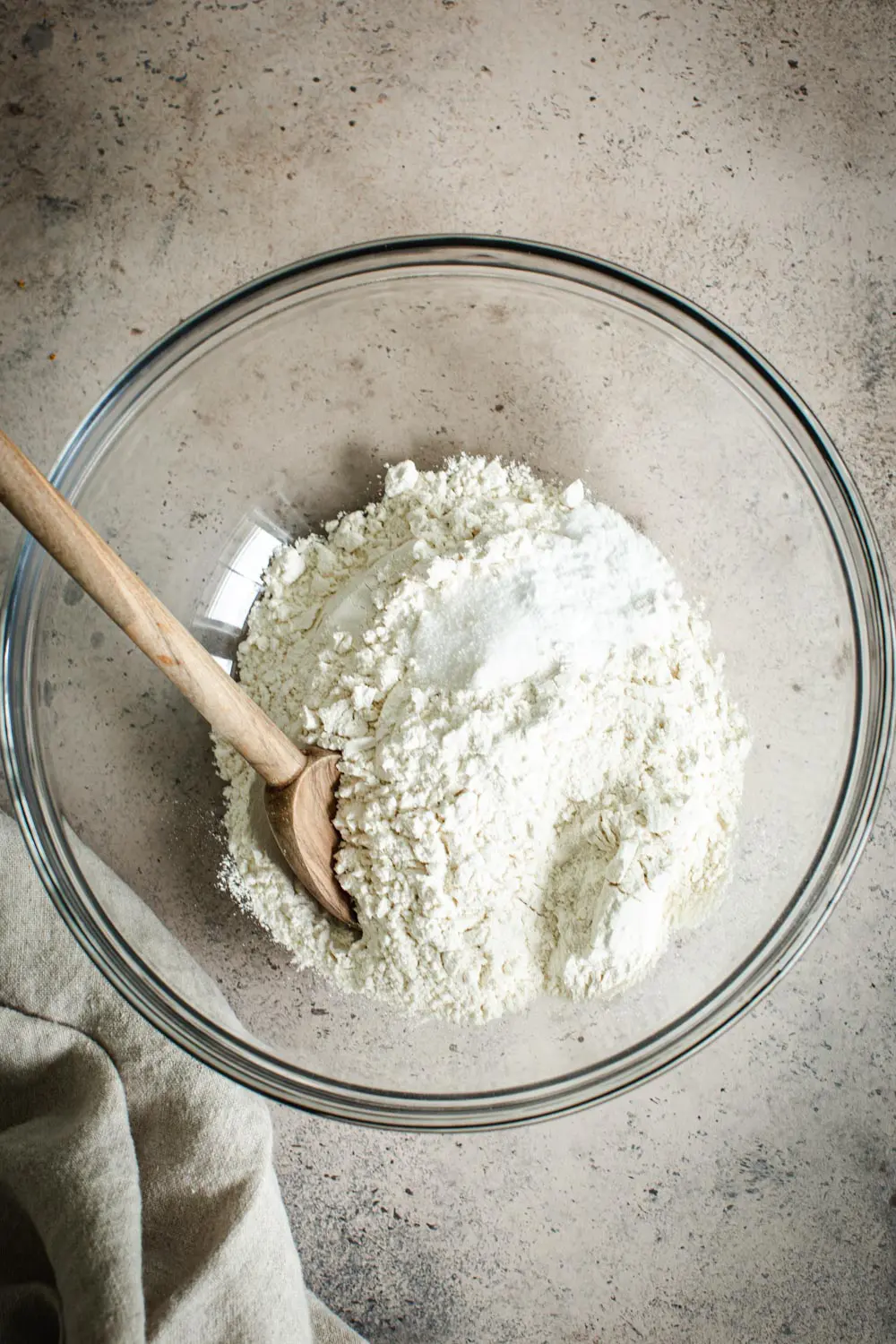 Dry ingredients for banana muffins in a glass mixing bowl.