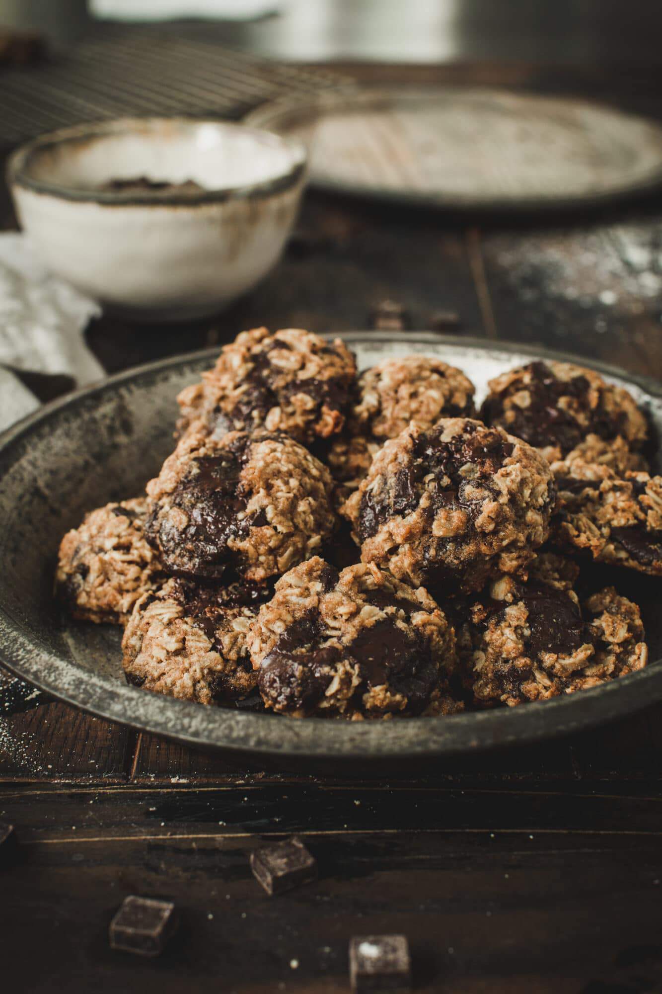 Oatmeal cookies in metal pie tin on wooden table.