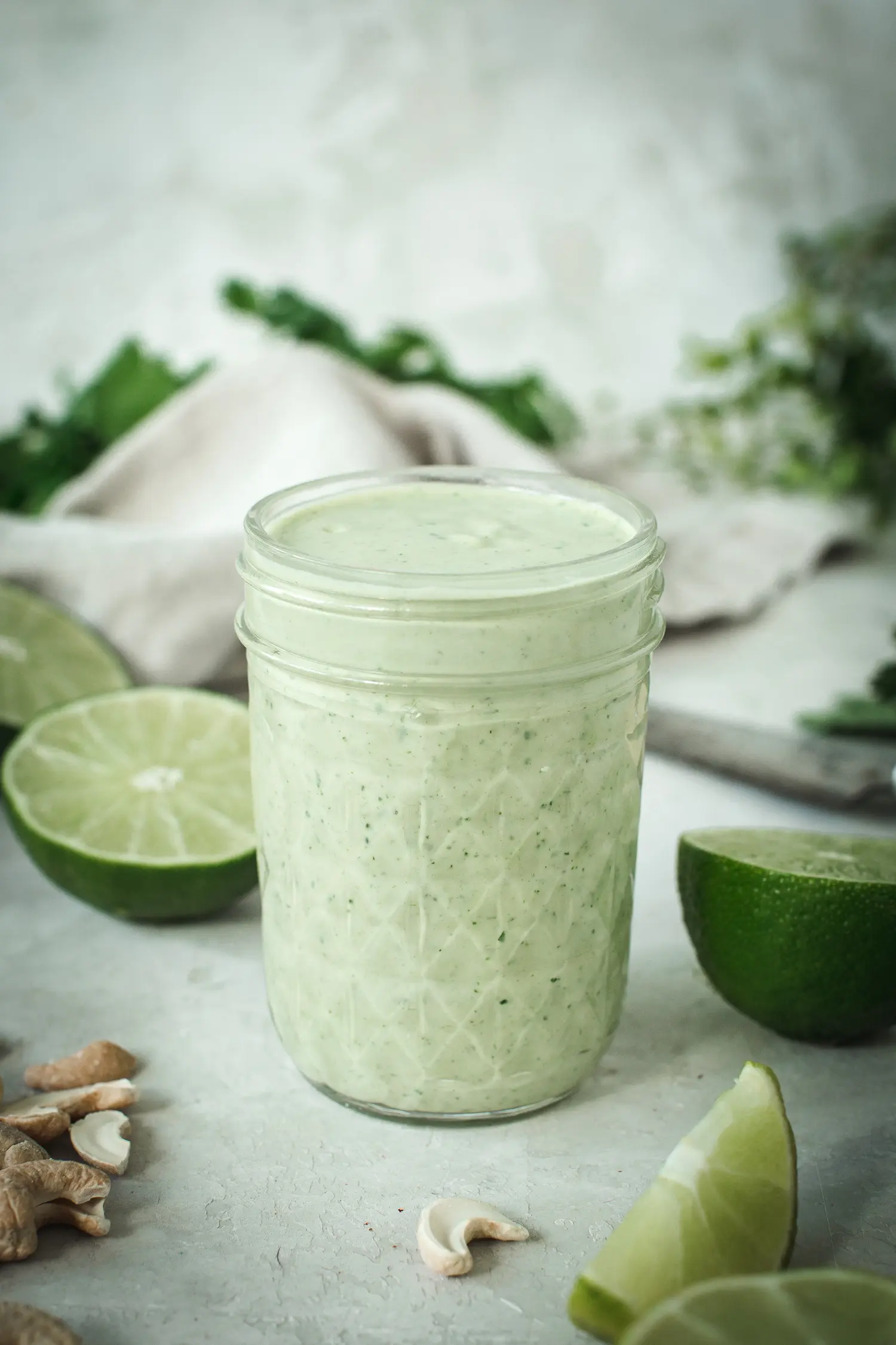 Lime crema in glass quilted jar with lime surrounding.