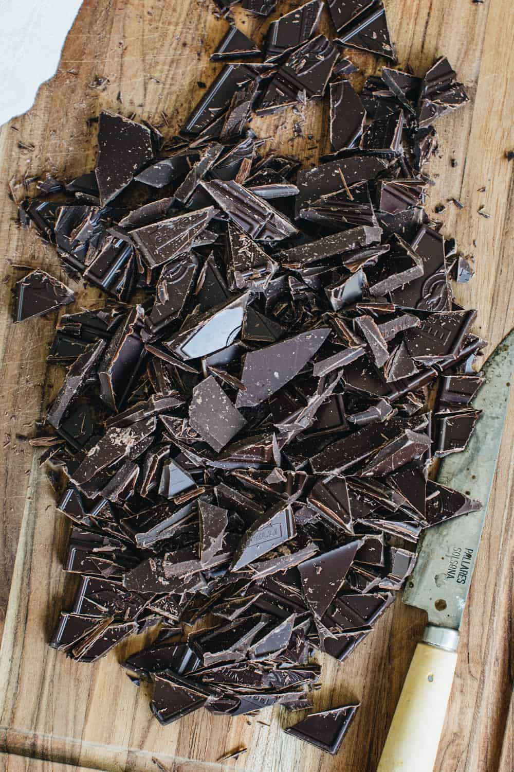 Chopped chocolate on a cutting board.