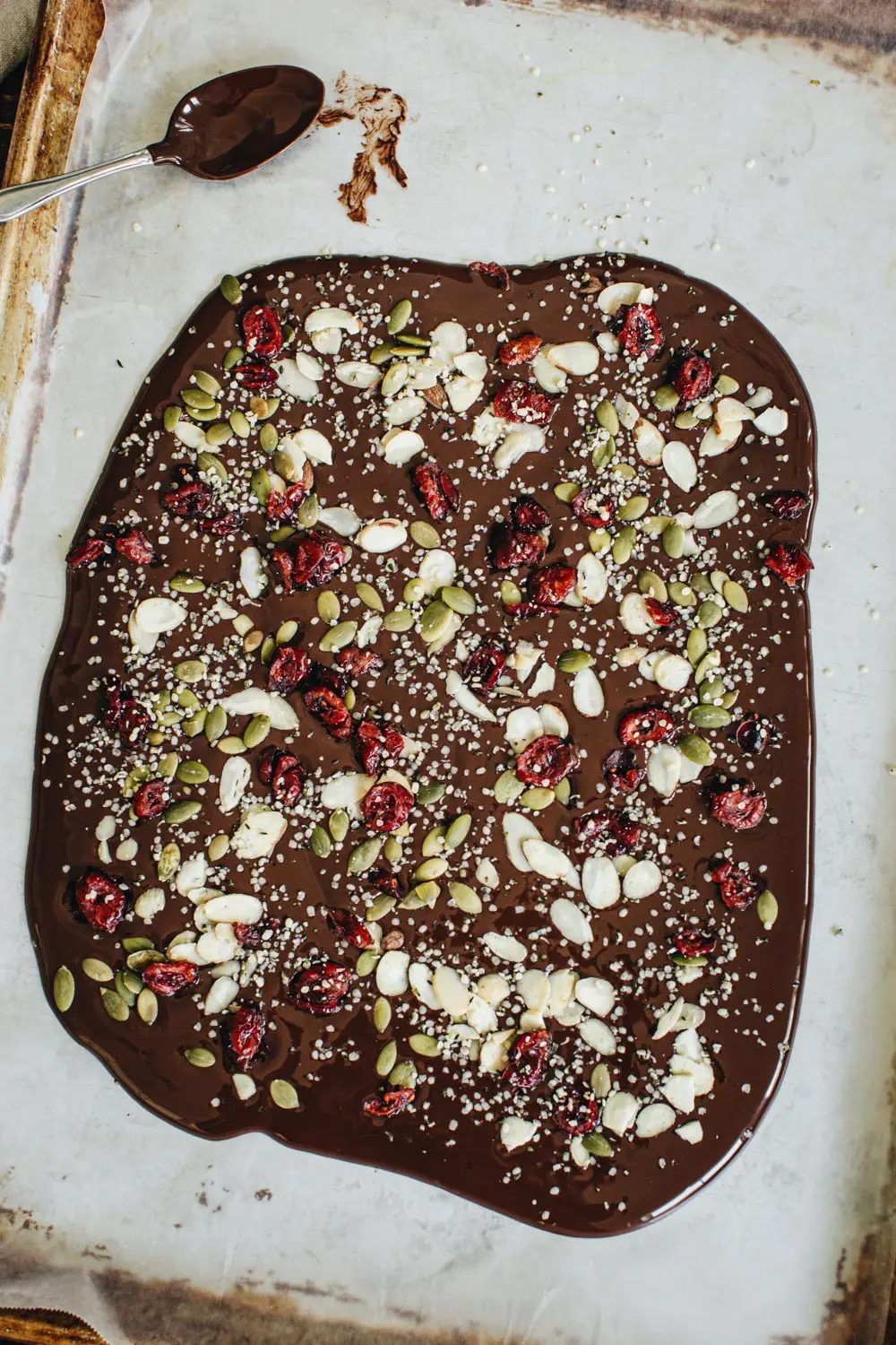 Healthy chocolate bark spread on parchment paper.