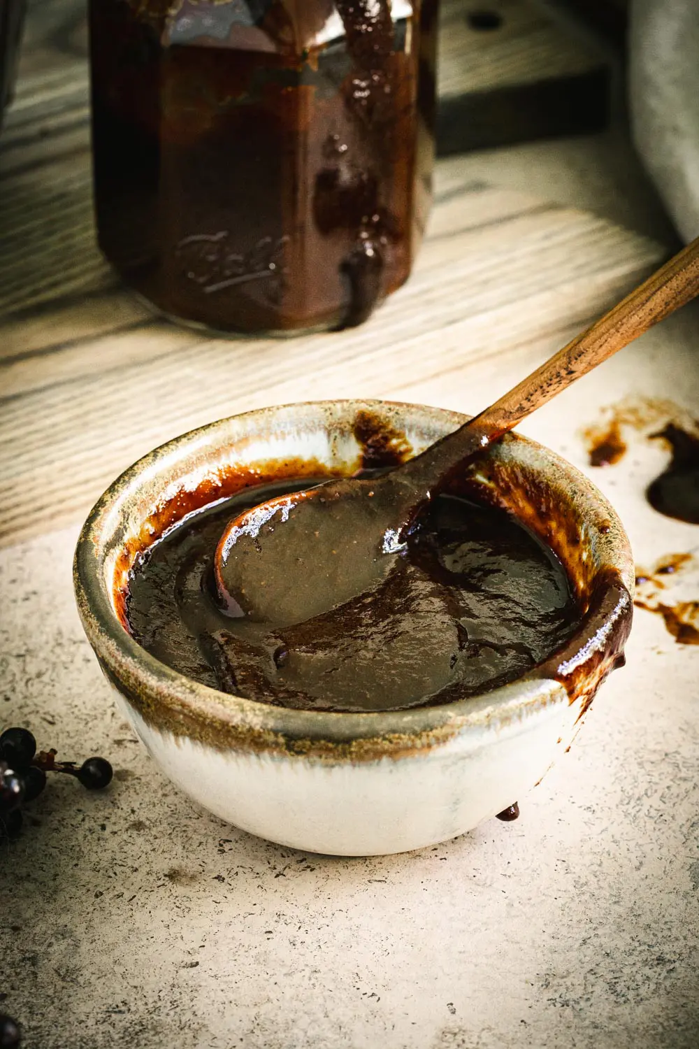 barbecue sauce in a pottery bowl with a wooden spoon