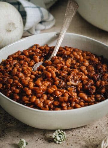 baked beans in bowl with silver serving spoon
