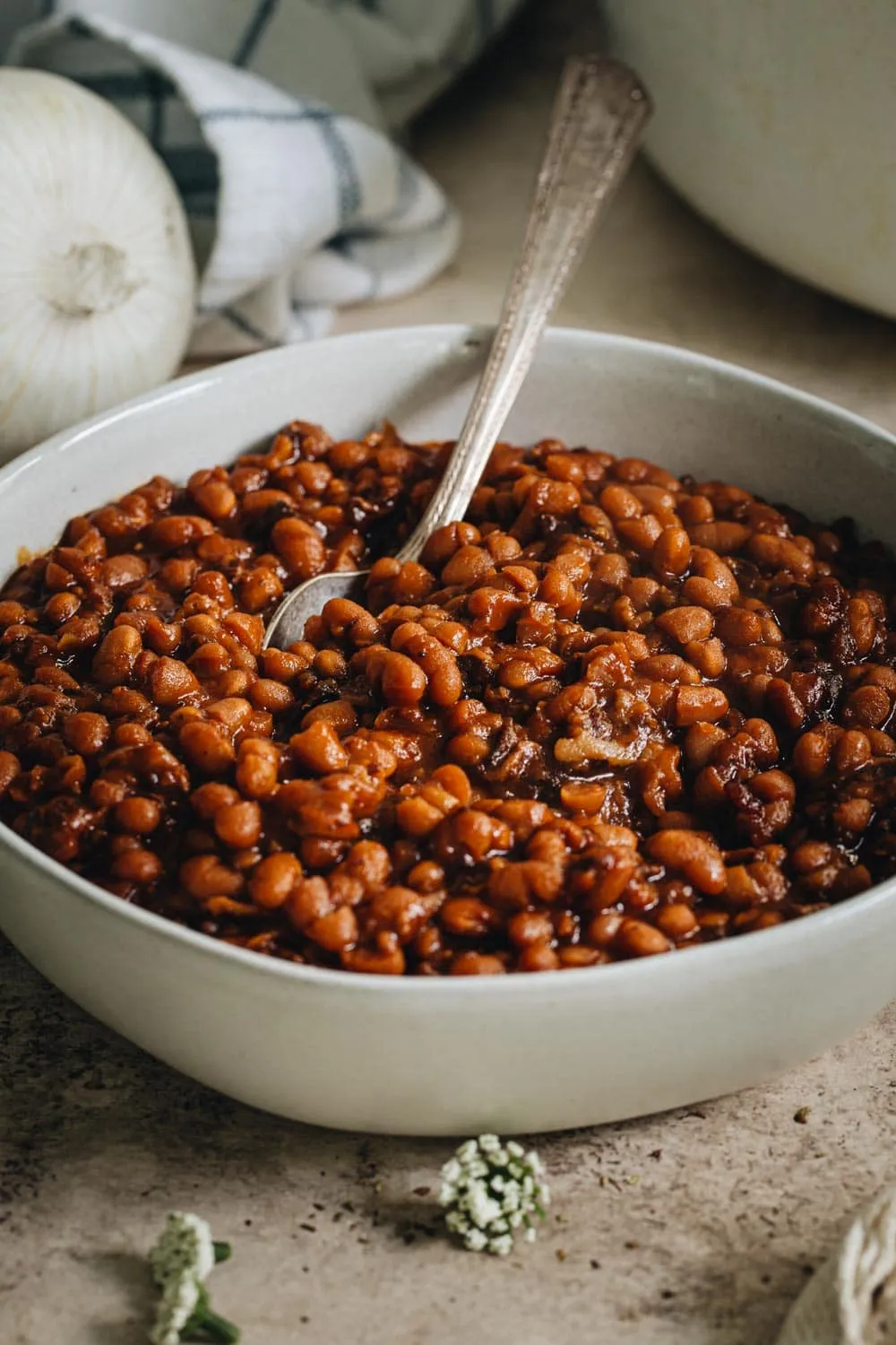 baked beans in a large bowl with silver serving spoon