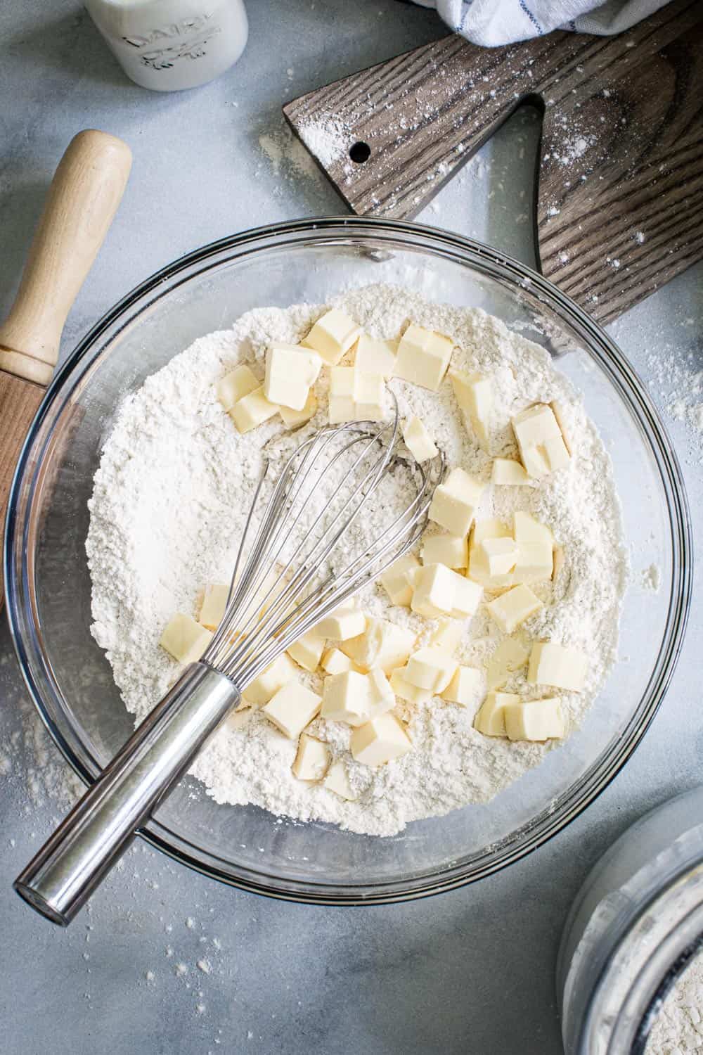 Butter cubes in pie dough flour mixture in glass bowl.