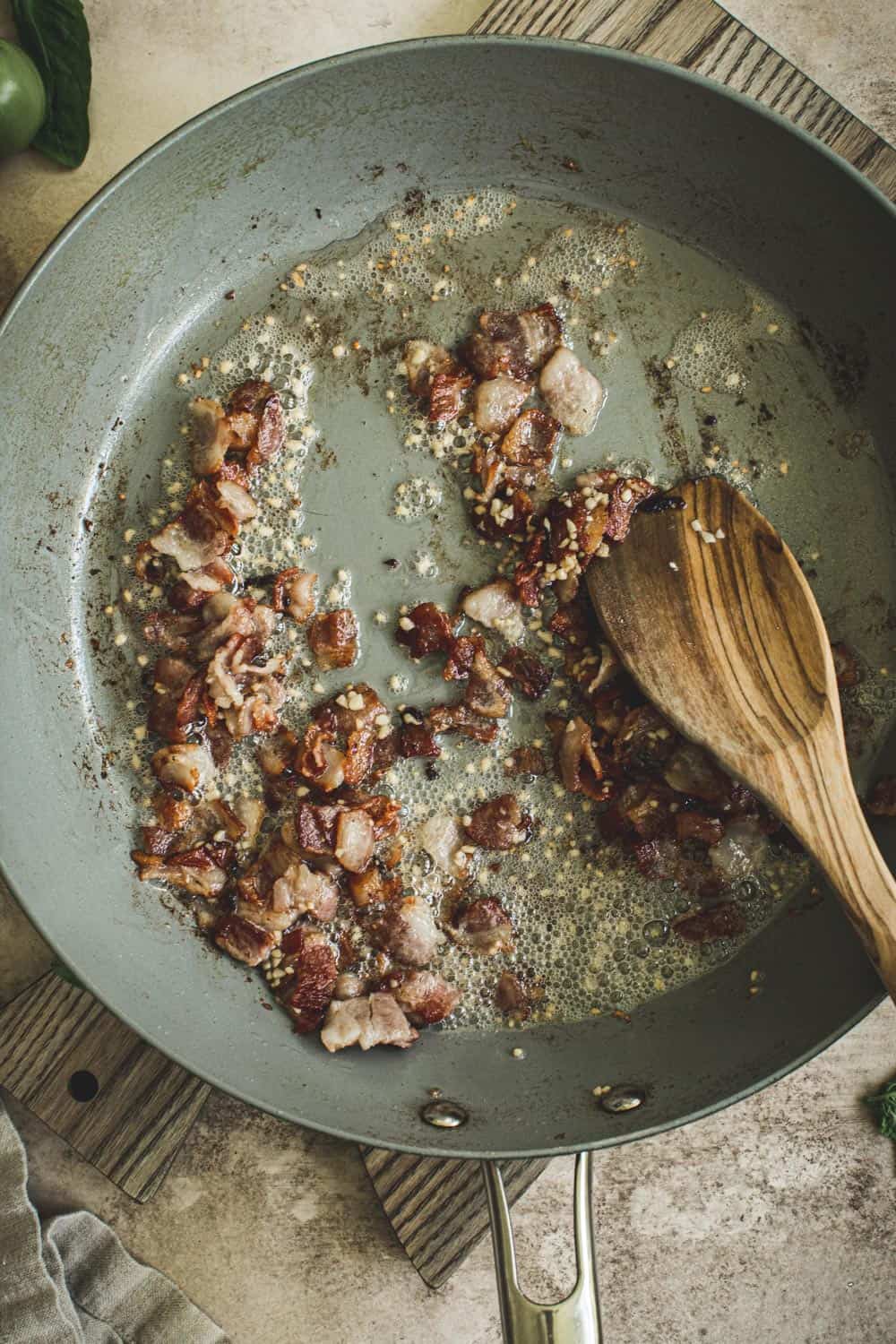 Bacon and garlic cooking in a skillet.