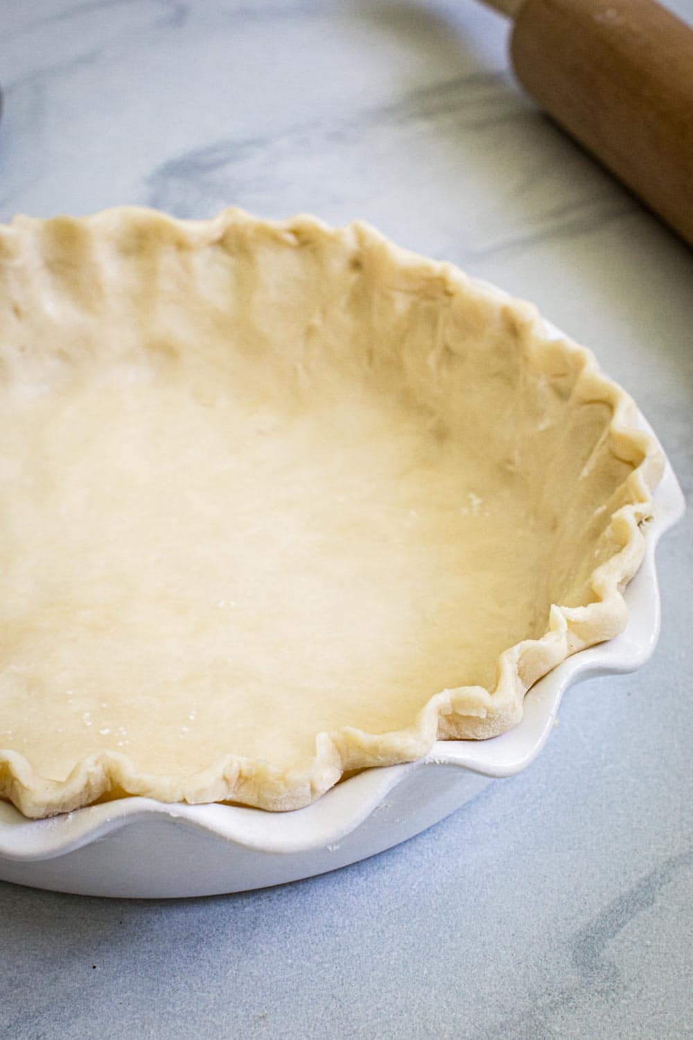 Side view of buttermilk pie crust in pie dish.