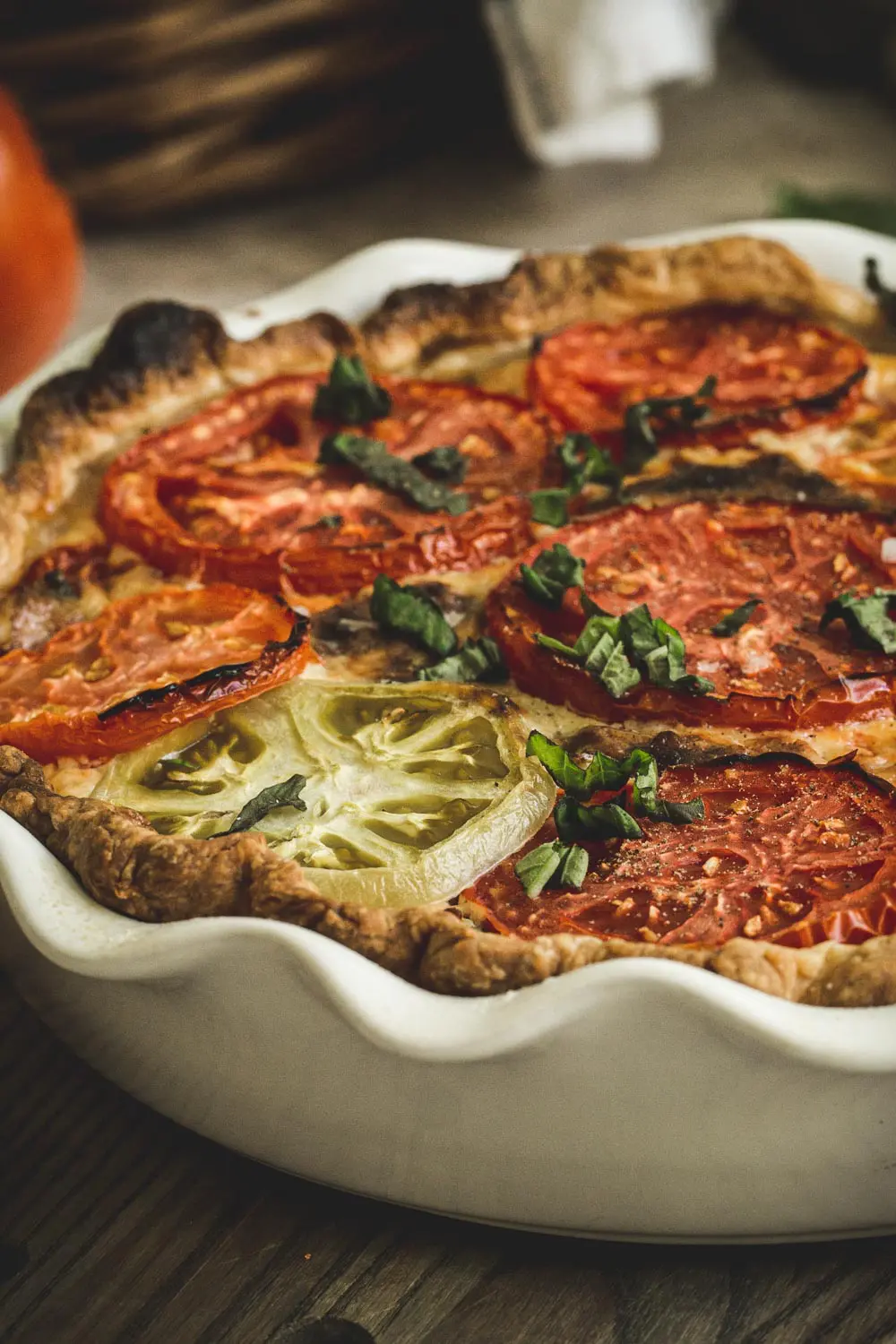 side view of tomato pie topped with fresh basil