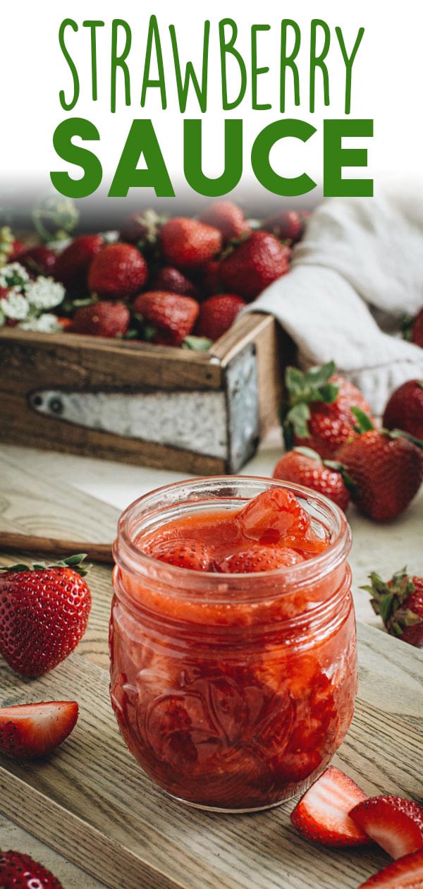 Strawberry sauce in glass jelly jar on wooden cutting board. Image for Pinterest.