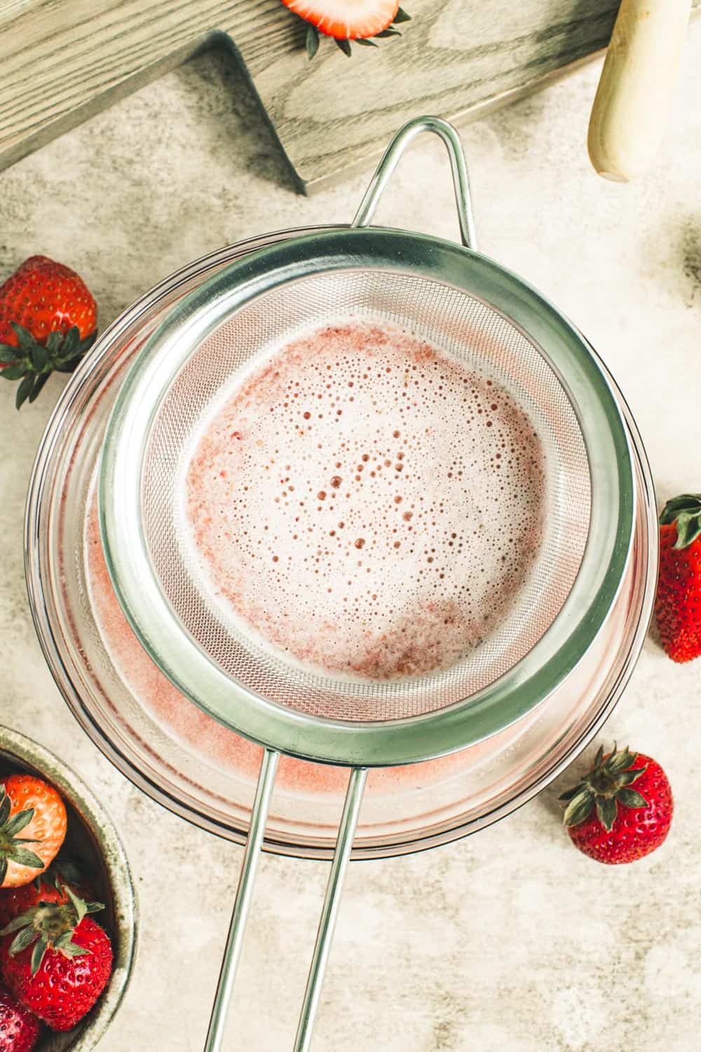 Mesh sieve with strawberry puree draining.