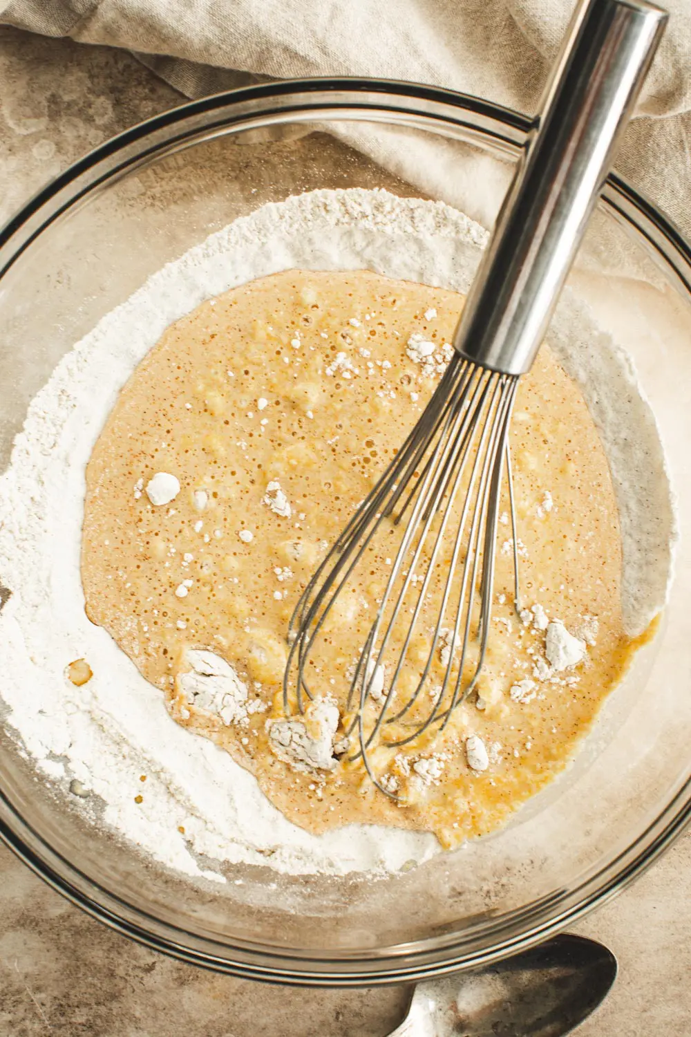 Mixing the pumpkin pancake batter together in a glass bowl.