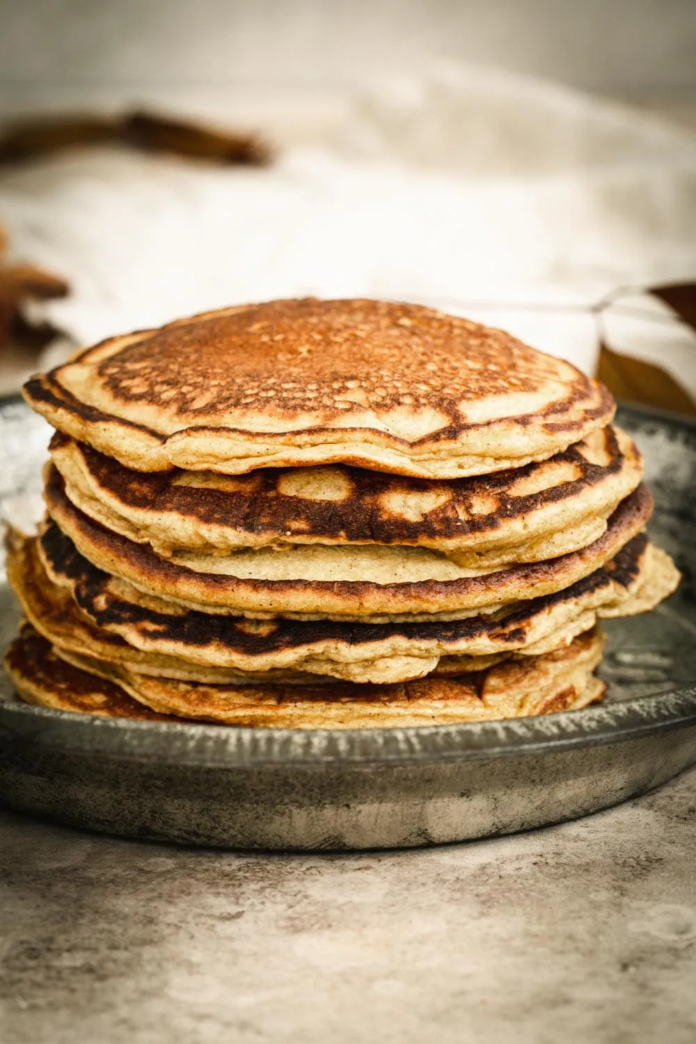 Plain stack of pumpkin pancakes in a metal pie tin.