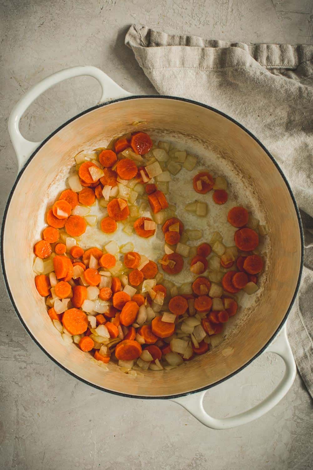 Sautéing the carrots and onions in the pumpkin white bean chili.