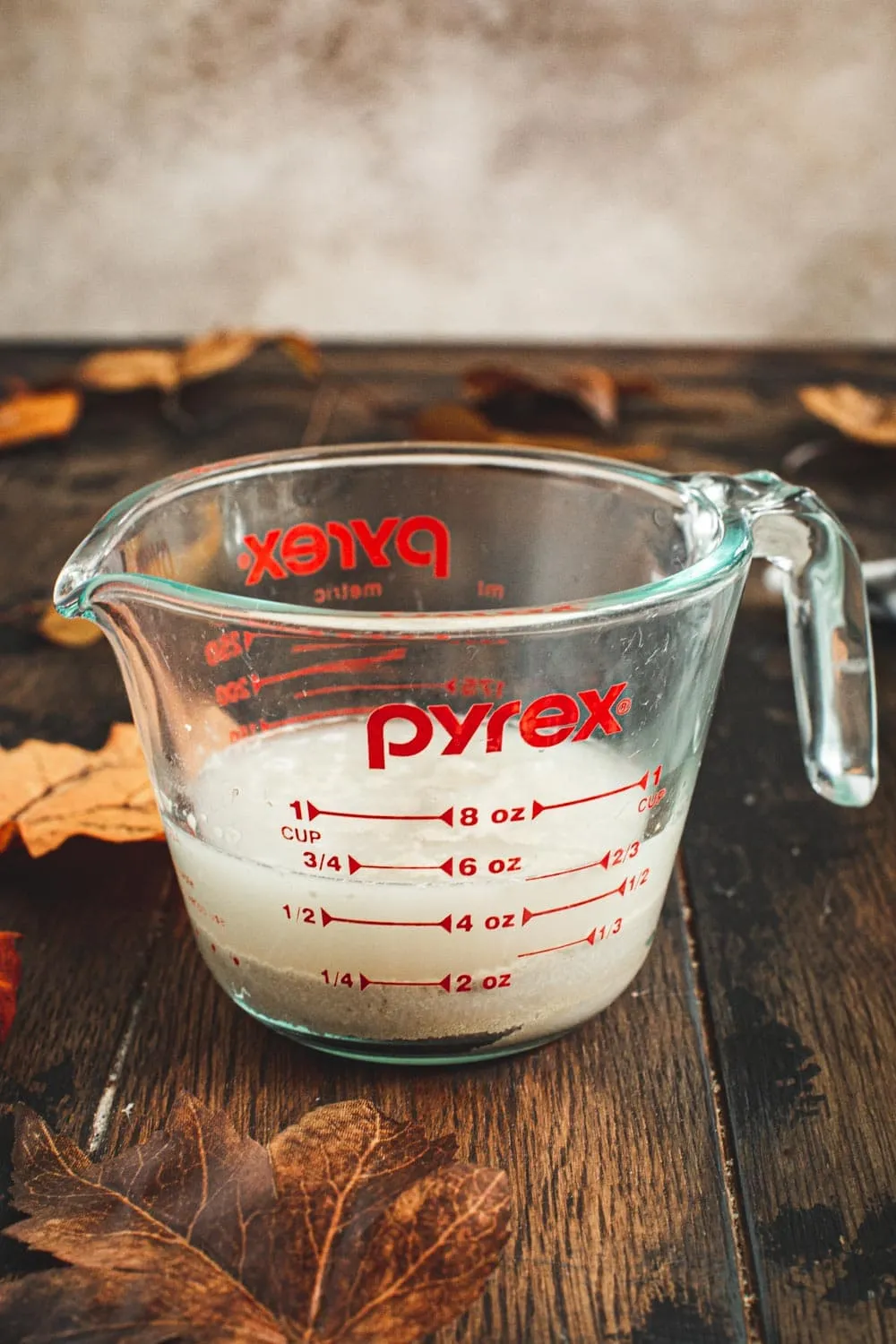 Warm water with active dry yeast in a measuring cup.