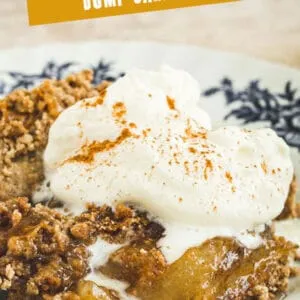 Caramel apple dump cake topped with cinnamon whipped cream with orange and white title for Pinterest.