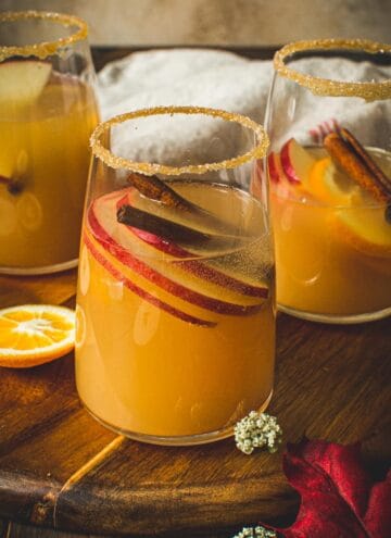 Glass of caramel apple sangria with a caramel and sugar coated rim.