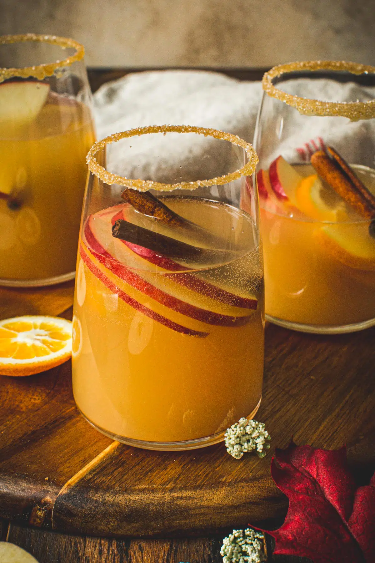 Glass of caramel apple sangria with a caramel and sugar coated rim.