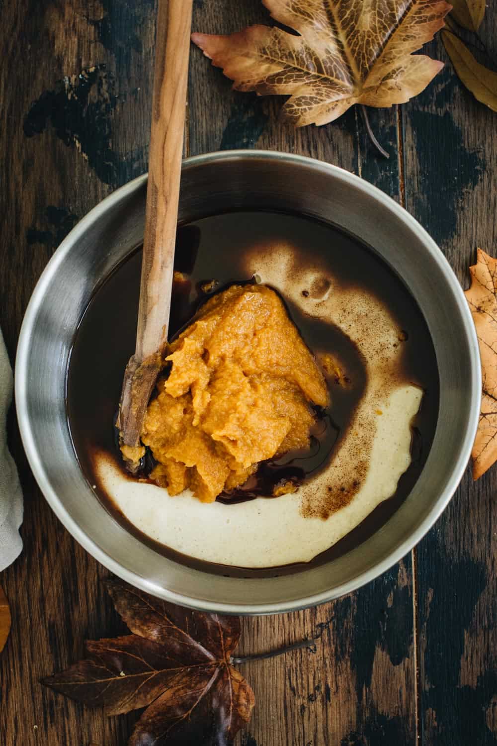 Pumpkin batter for pumpkin swirl brownies in a silver mixing bowl.