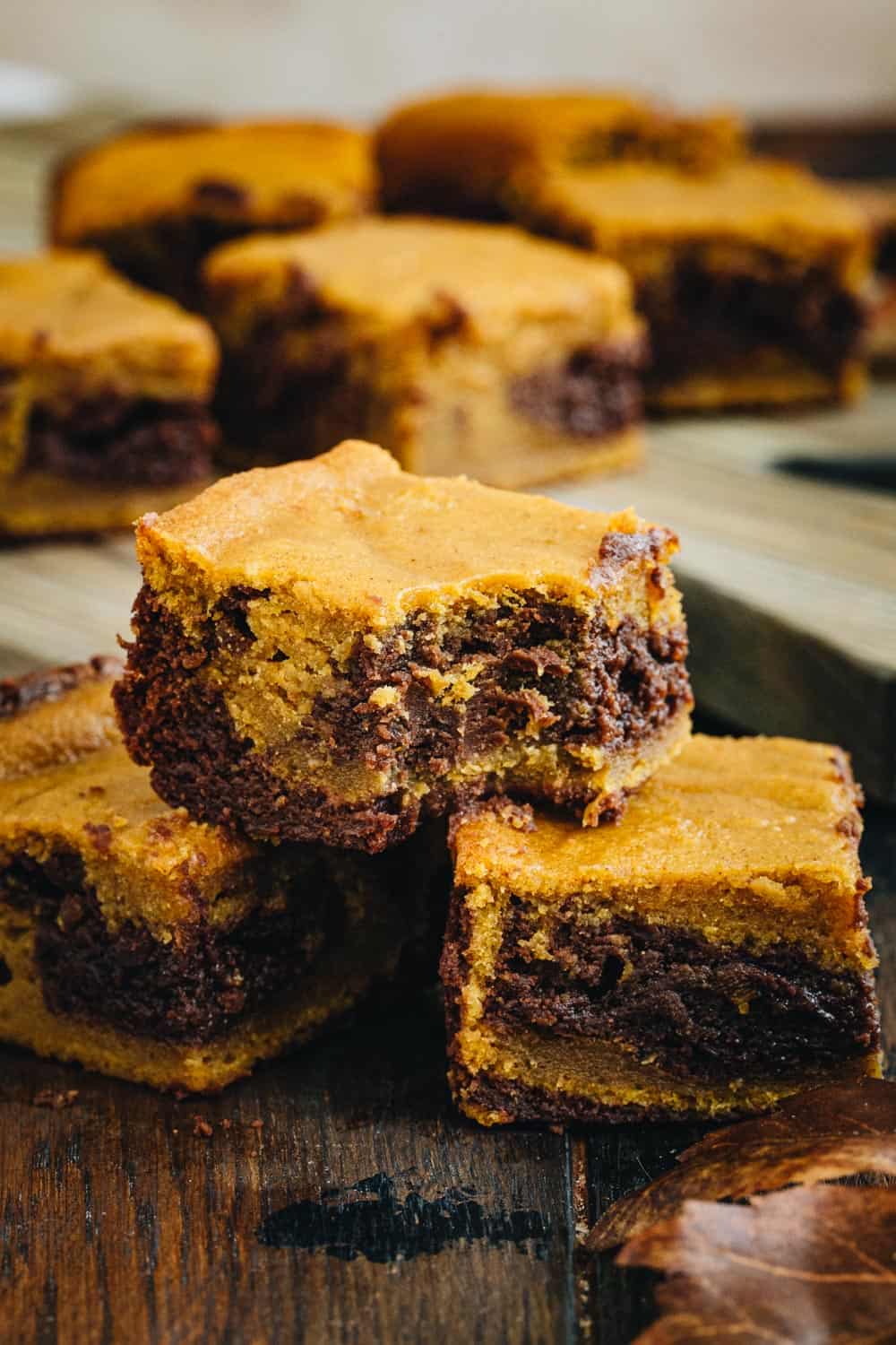 Chocolate and Pumpkin Brownies stacked on top of each other with a bite taken out of one.