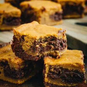 Pumpkin swirl brownies stacked on top of each other.