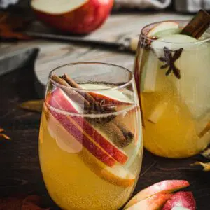 Apple cider sangria with fruit in a stemless wine glass.