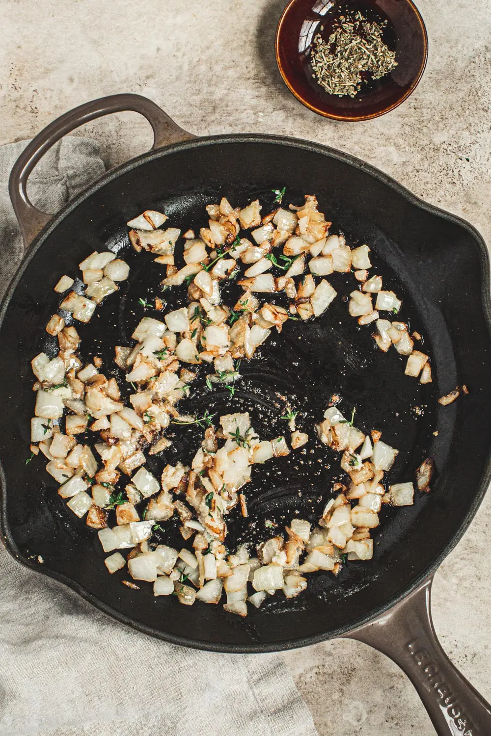 Sautéed onions with fresh thyme in an iron skillet.