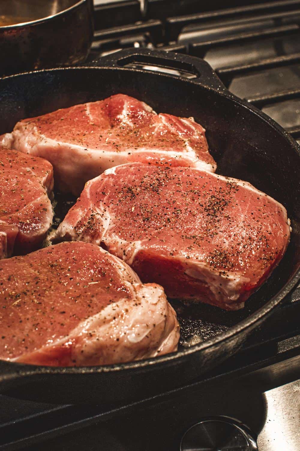 Pork chops in an iron skillet.