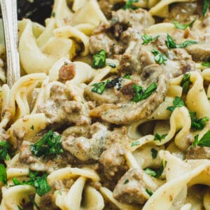 Ground Beef Stroganoff in a large skillet with a silver serving spoon.