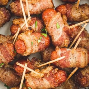 Toothpicks inserted into bacon-wrapped little smokies.