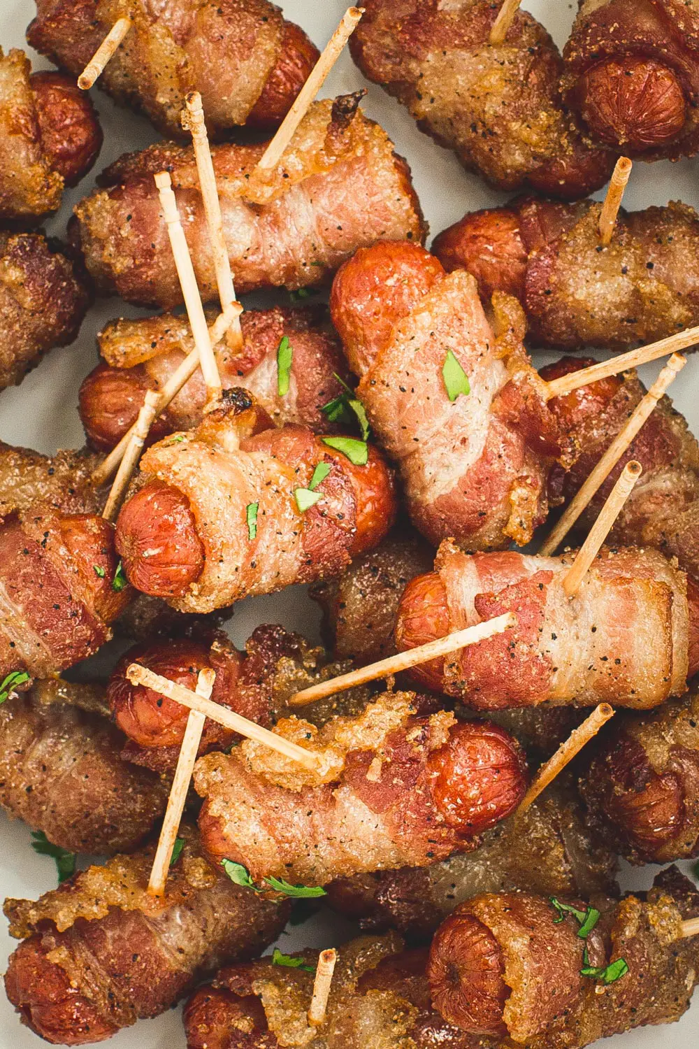 Toothpicks inserted into bacon-wrapped little smokies.
