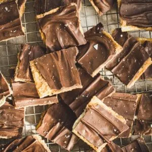 Pieces of toffee bark spread out on a wire rack.