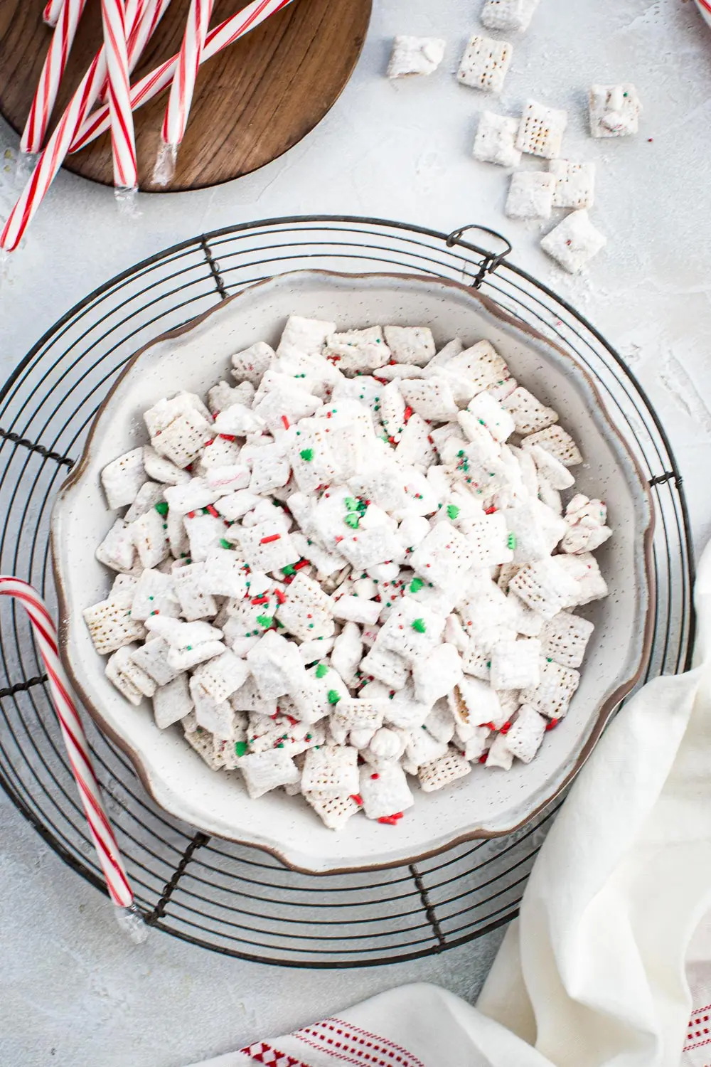Large bowl of Christmas puppy chow with white chocolate and sprinkles mixed in.