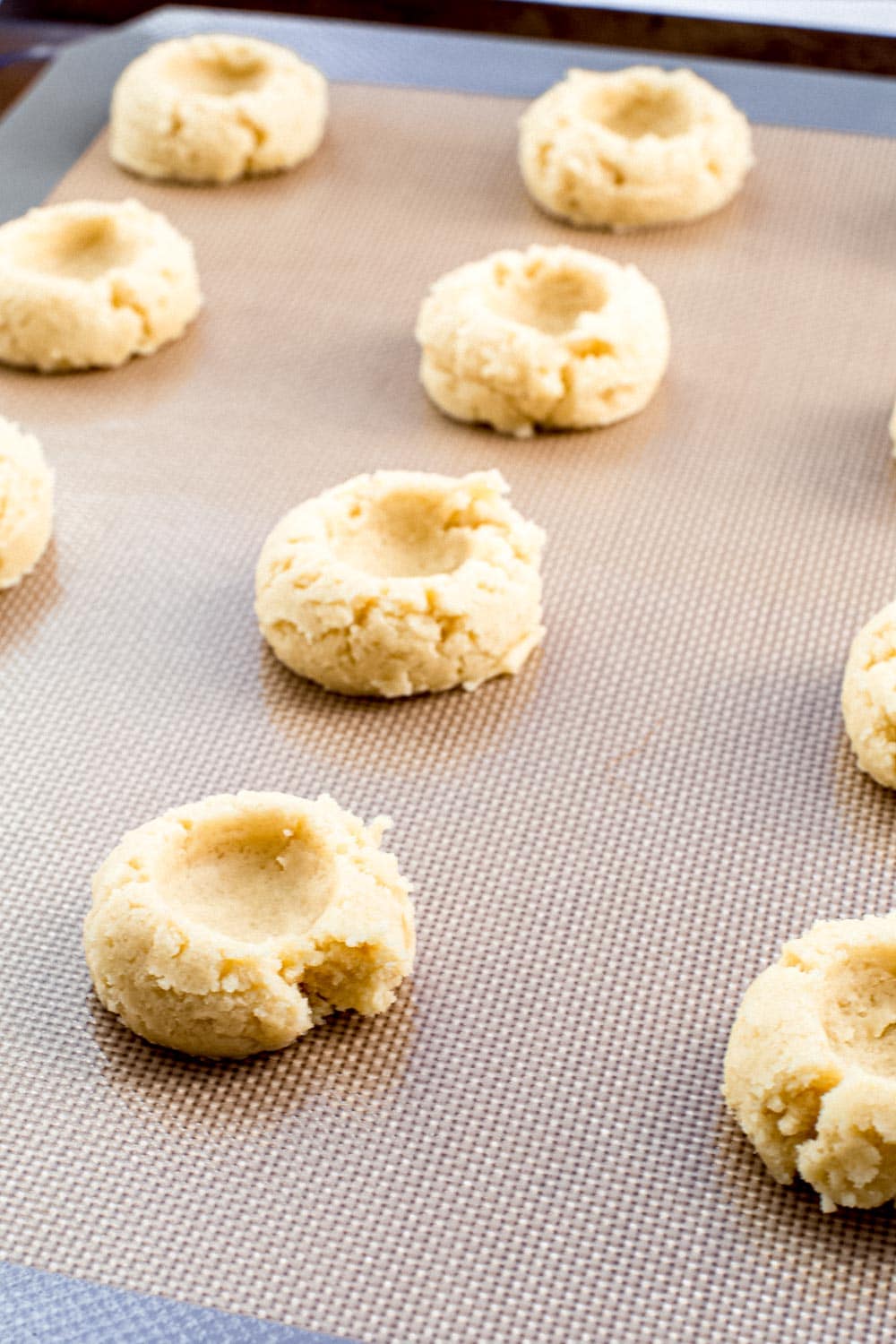 Thumbprint cookies on baking sheet.