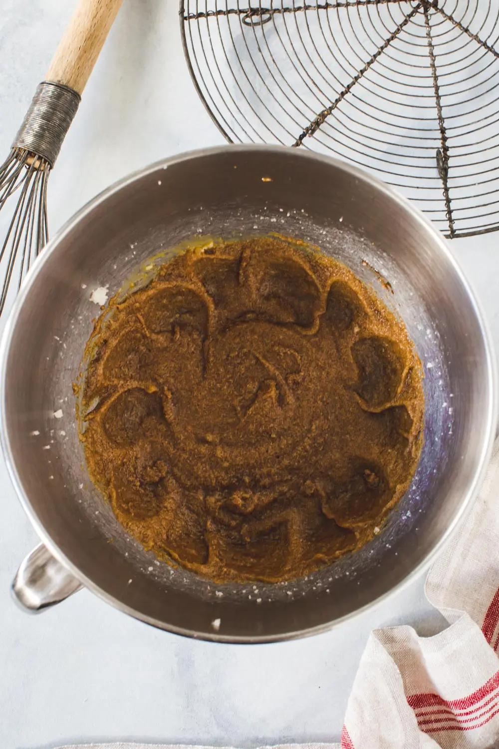 Butter and molasses mixture for gingerbread cookies in mixing bowl.