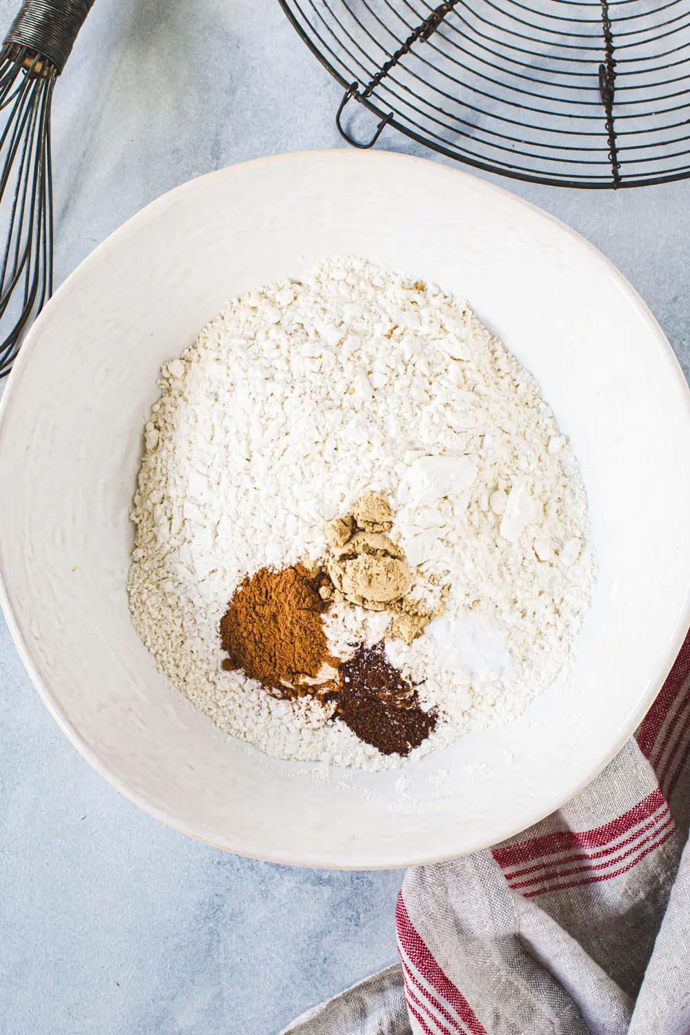 Gingerbread cookie dry ingredients in a white mixing bowl.