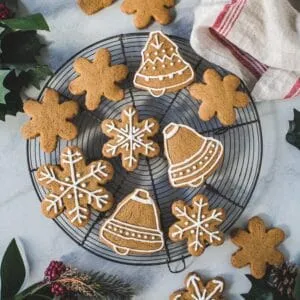 Gingerbread cookies with royal icing on a round wire baking rack.