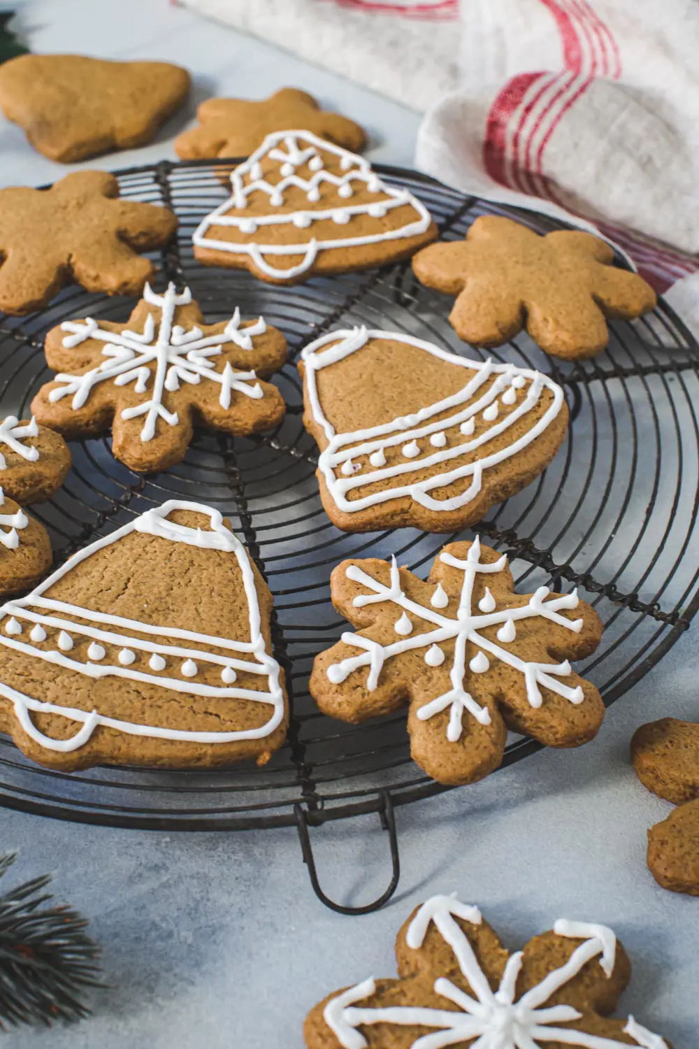 Gingerbread cookies covered with icing on a round wire rack.