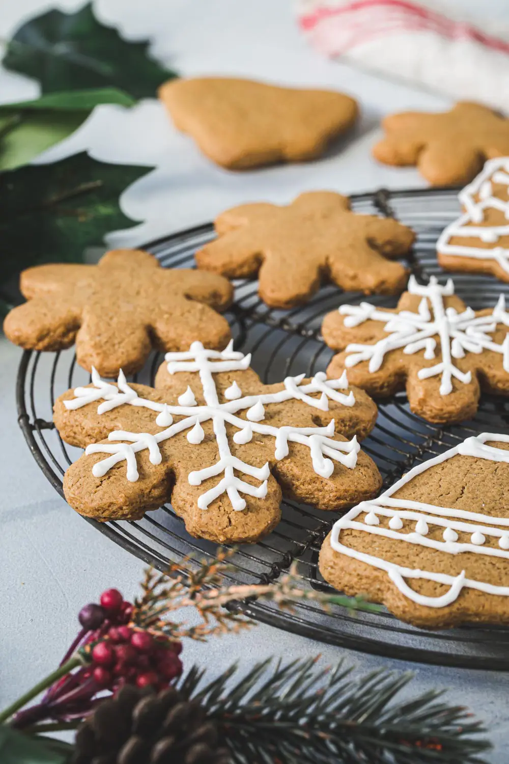 Gingerbread cutout cookies iced on a round wire rack.