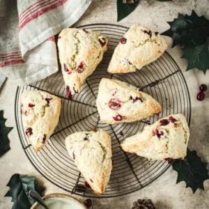 Cranberry Orange Scones on a wire rack with a red and white dish towel next to it.