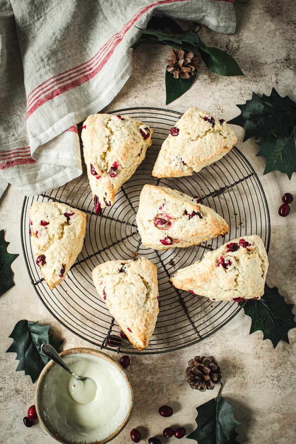 Cranberry Orange Scones on a wire rack with a red and white dish towel next to it.