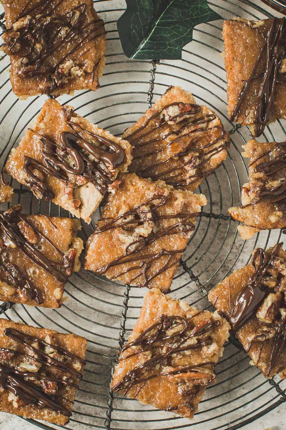 Praline bars drizzled in chocolate on a wire rack.